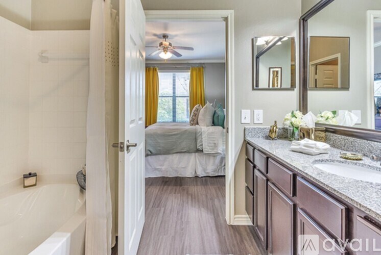 A bathroom with a bedroom in the background.