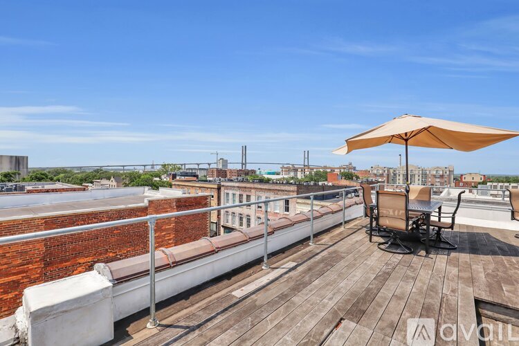 A wooden deck with a white couch and a sun umbrella.
