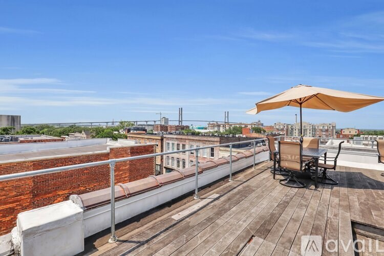 A wooden deck with a white couch and a sun umbrella.
