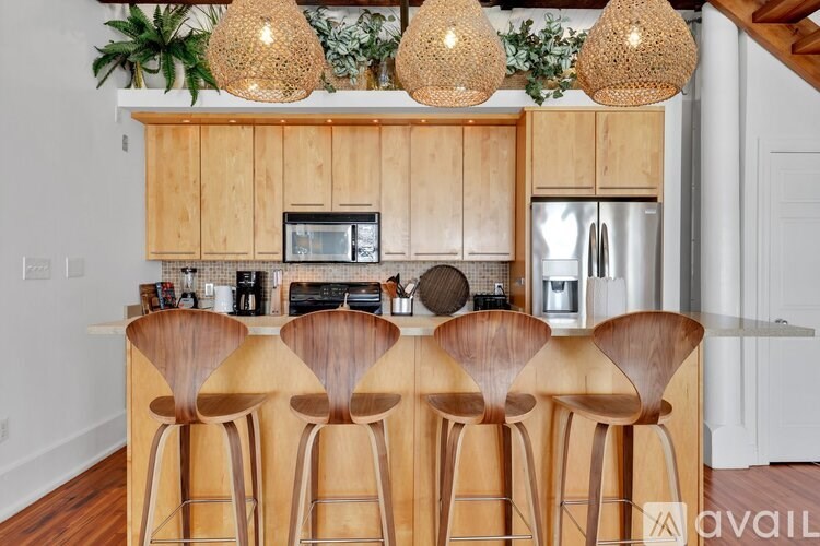 A kitchen with wooden chairs and cabinets.