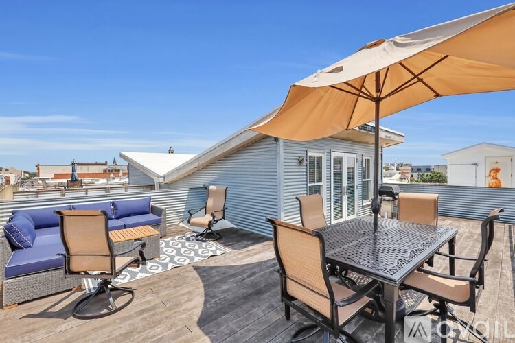 A patio with a table and chairs under an umbrella.