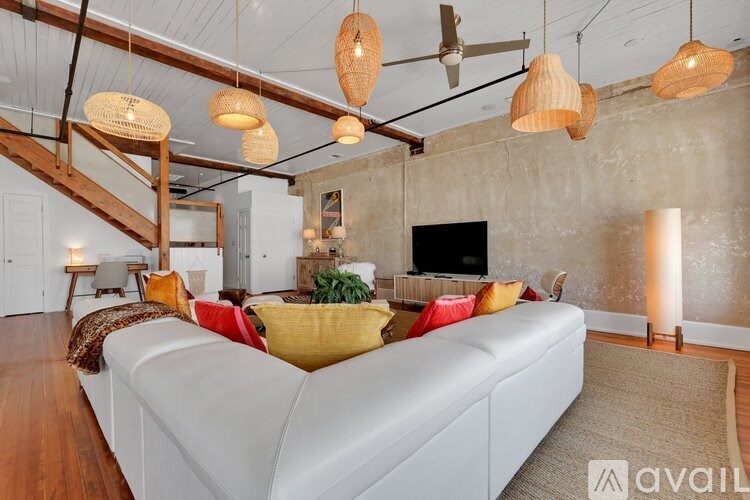 A living room with a white couch and wooden beams.