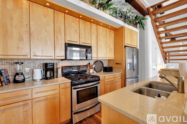 A kitchen with wooden cabinets and a stainless steel refrigerator.