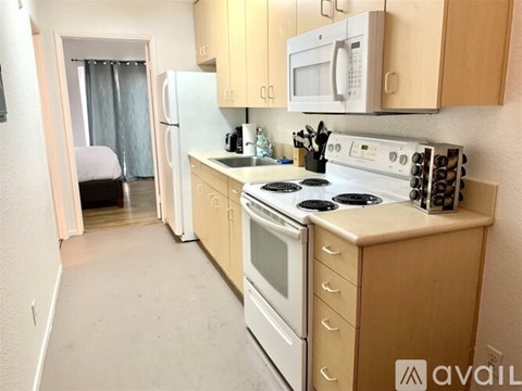 A kitchen with a stove, refrigerator, and microwave.
