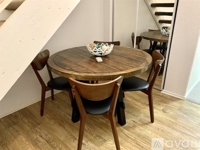 A round wooden table with four chairs around it.