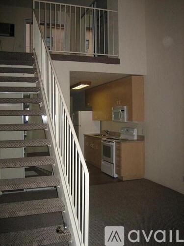 A staircase with a metal railing leads to a second floor.