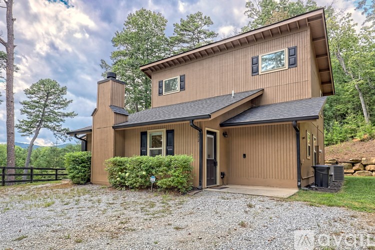 A modern house with a brown exterior and a black roof.