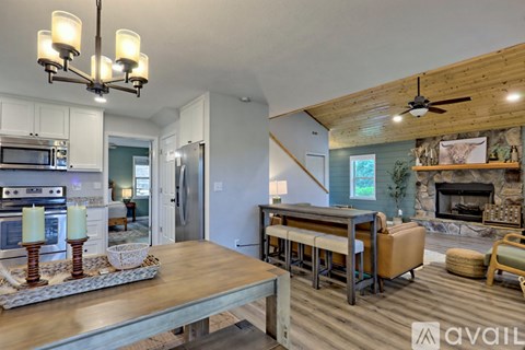 A modern kitchen with a wooden ceiling and a dining table with chairs.