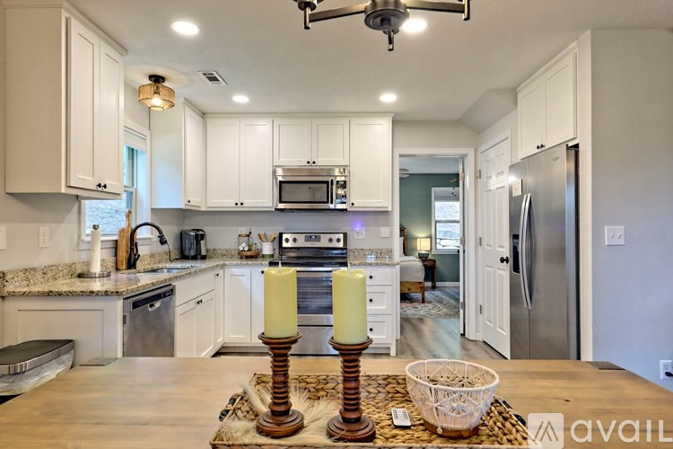 A kitchen with a wooden table and two candles on it.