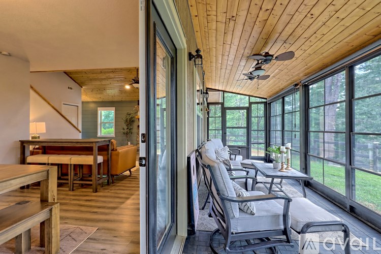 A sunroom with a table and chairs is shown.