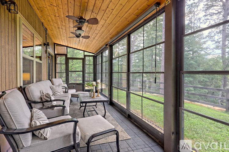 A sunroom with a ceiling fan and sliding glass doors.