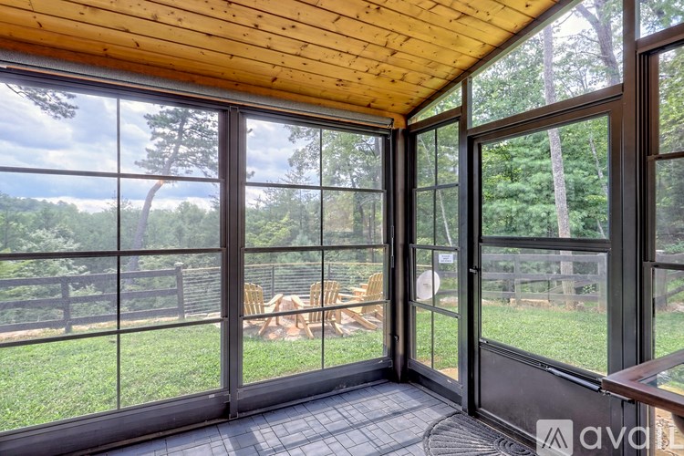 A wooden deck with glass doors opens to a lush green backyard.