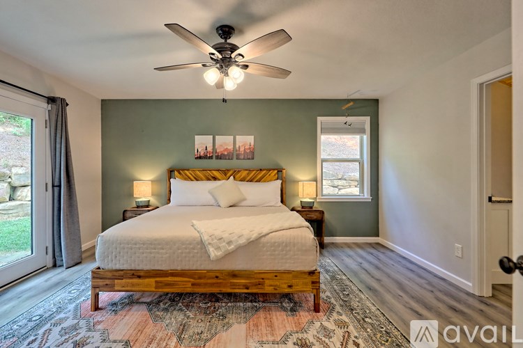 A bedroom with a large bed and a ceiling fan.