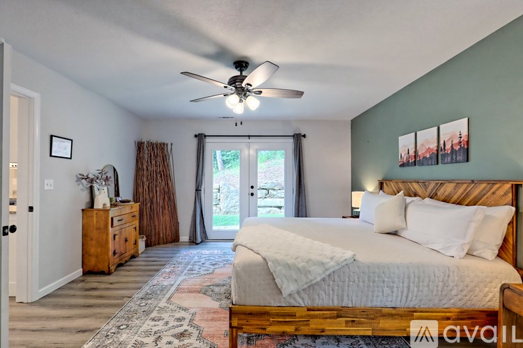 A bedroom with a large bed and a ceiling fan.