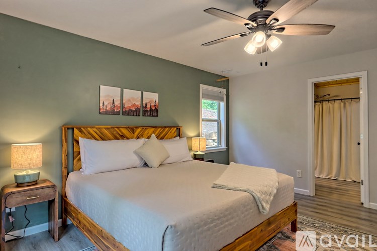 A bedroom with a large bed and a ceiling fan.