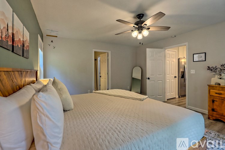 A bedroom with a large bed and a ceiling fan.