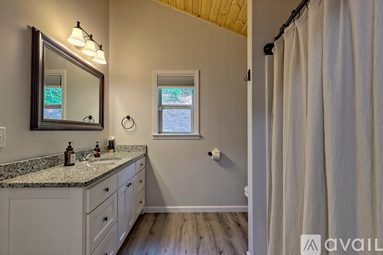 A bathroom with a granite countertop and a window.