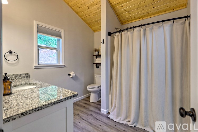 A bathroom with a wooden ceiling and a window.