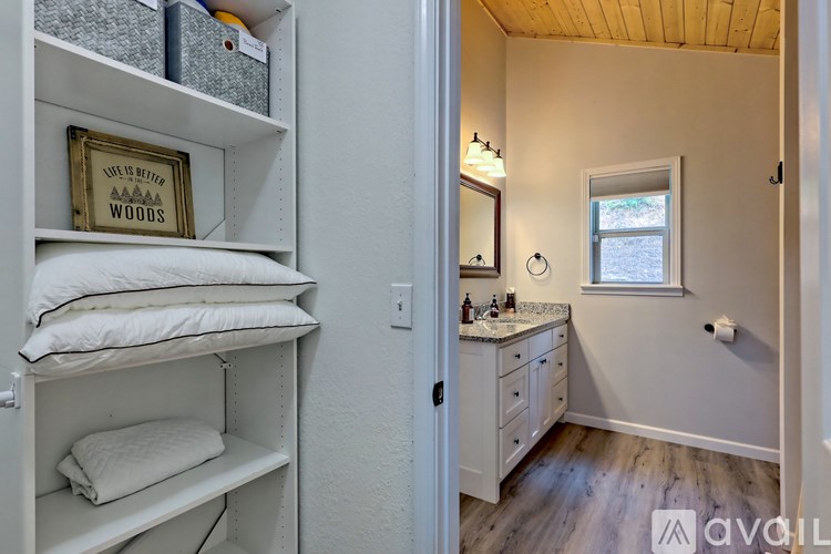 A bathroom with a white cabinet and a mirror above it.