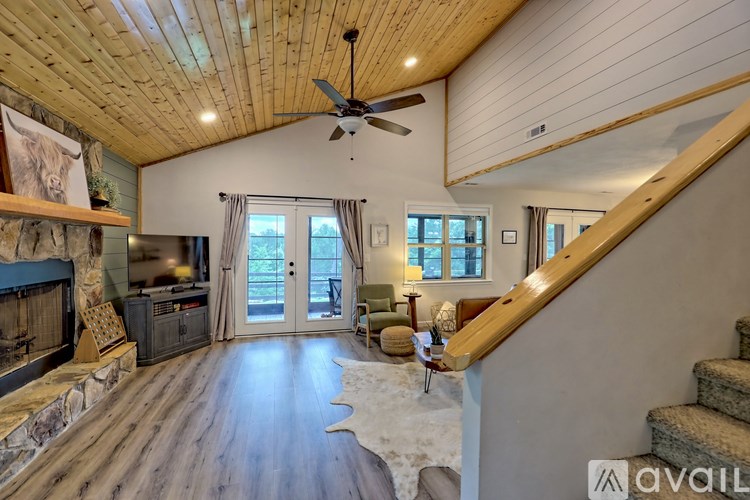 A spacious living room with a fireplace and a cowhide rug.