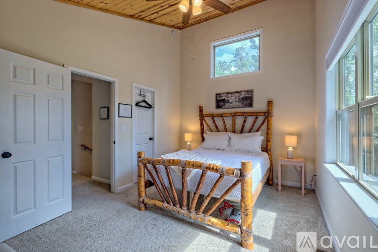 A bedroom with a bed, nightstand, and window.