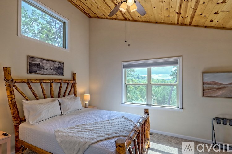 A bedroom with a large bed and a window overlooking a vineyard.