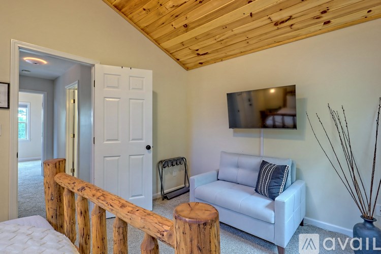 A living room with a white couch and a wooden railing.