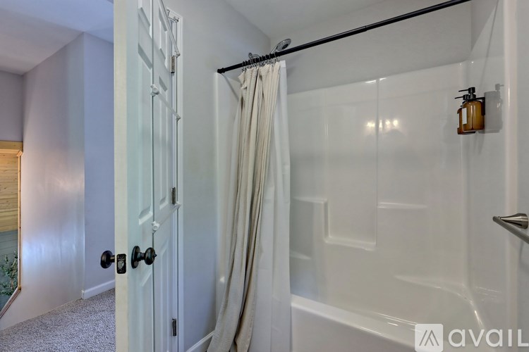 A bathroom with a glass shower door and a white door.