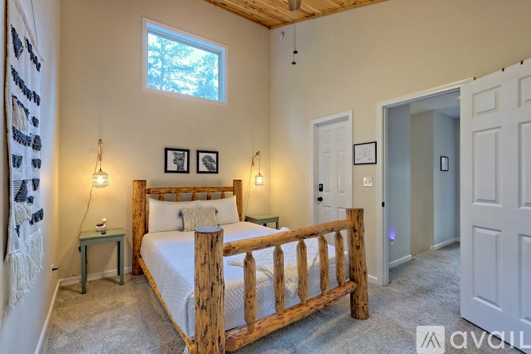 A bedroom with a bed, nightstands, and a window.