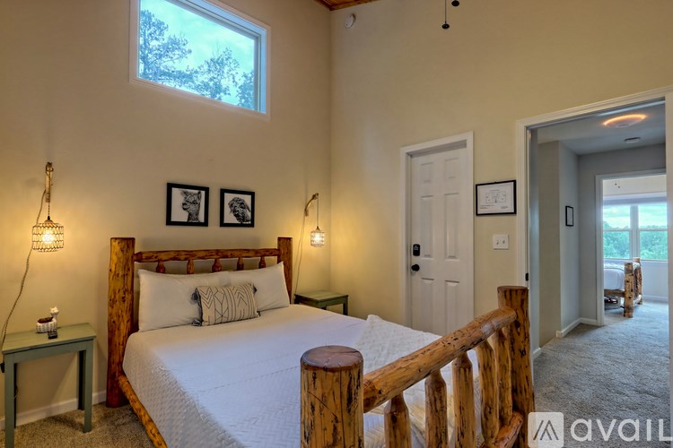 A bedroom with a bed, nightstand, and two wall lamps.