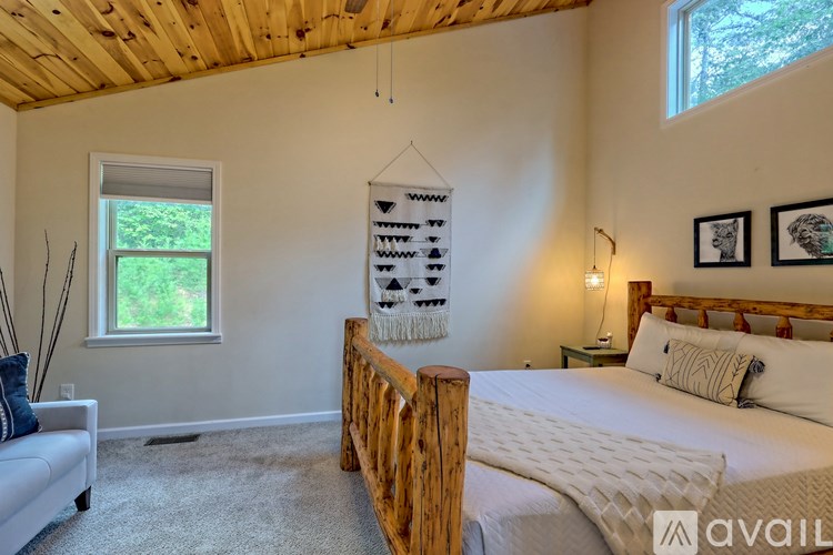 A bedroom with a wooden bed frame and a white bedspread.