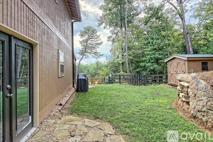 A backyard with a stone pathway leading to a wooden shed.
