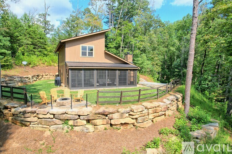 A house with a stone wall in front of it.