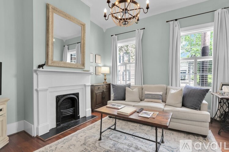 A living room with a fireplace, a sofa, and a chandelier.