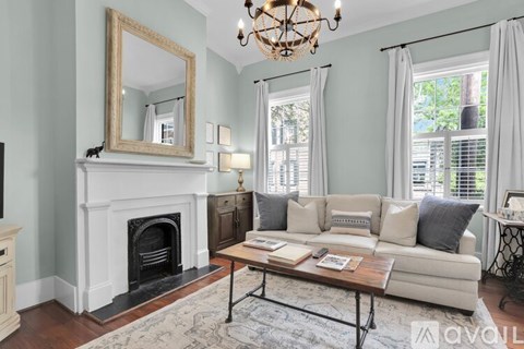 A living room with a fireplace, a sofa, and a chandelier.