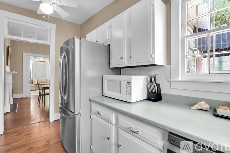 A kitchen with white cabinets and a stainless steel refrigerator.
