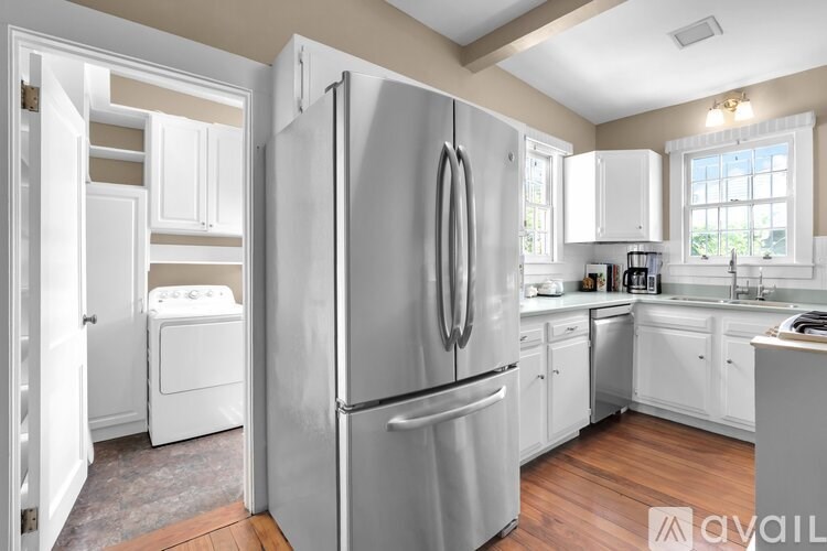 A modern kitchen with a large refrigerator and a washing machine.