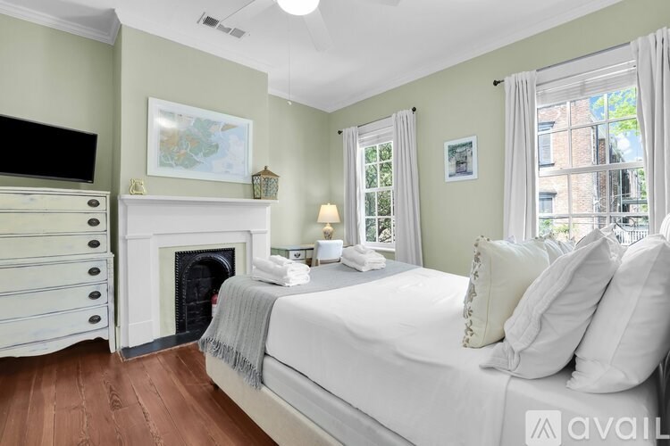 A bedroom with a fireplace and a large bed.