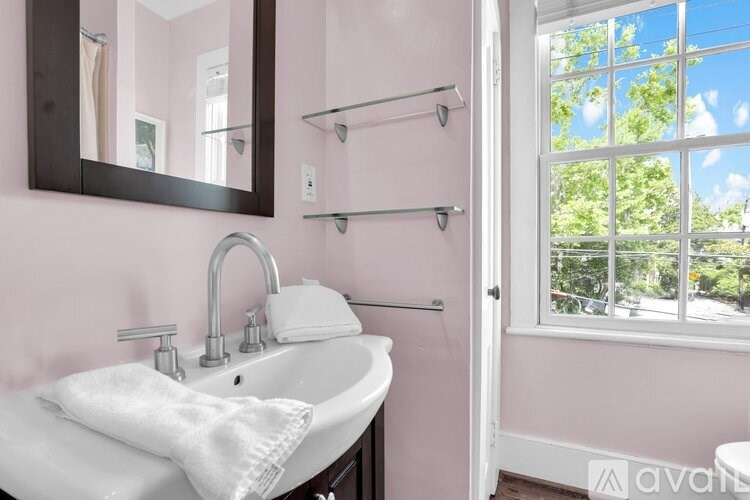 A bathroom with pink walls and a white sink.