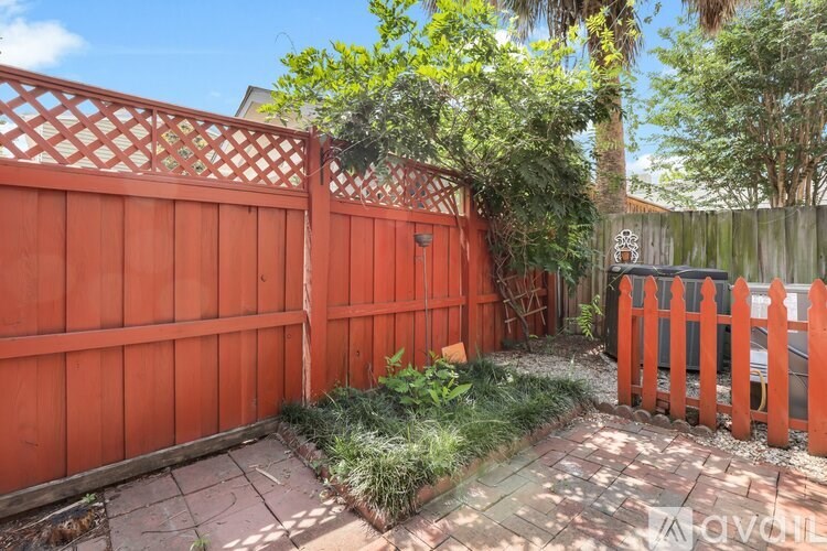 A red fence encloses a small garden area.