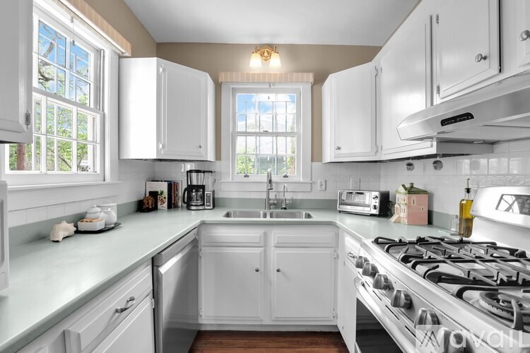 A kitchen with white cabinets and a stainless steel stove.