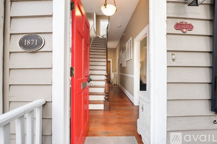 A red door with a plaque that says 1871 on the wall.