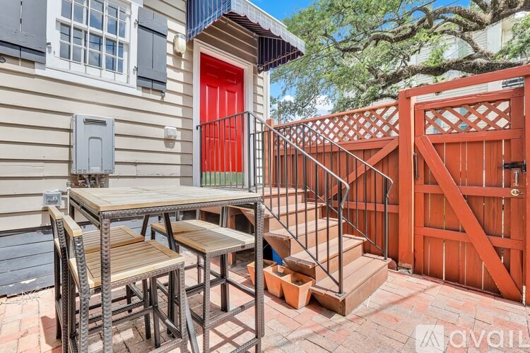 A patio with a table and chairs is in front of a house.
