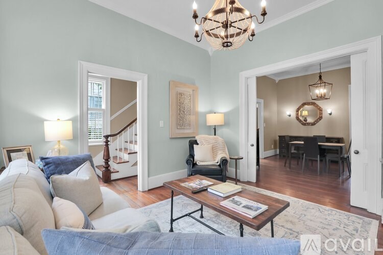 A living room with a couch, a coffee table, and a chandelier.