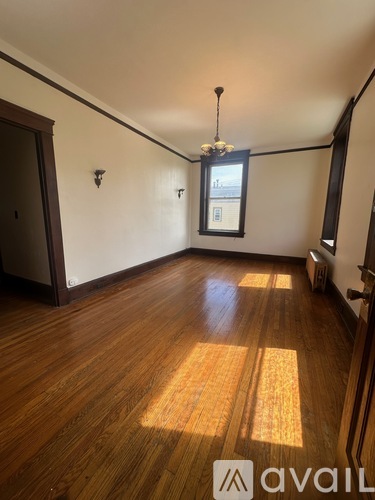 A room with wooden floors and a chandelier.