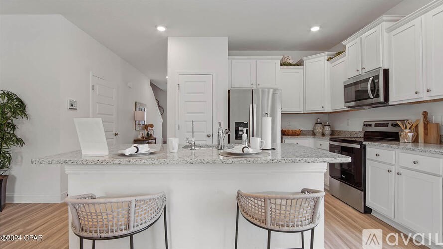 A kitchen with white cabinets and a white countertop.