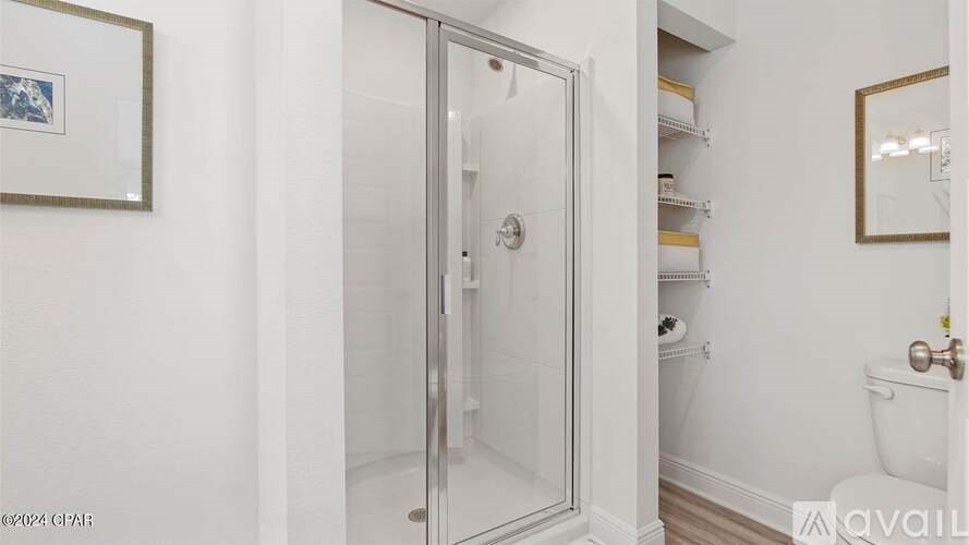 A white bathroom with a glass door shower.