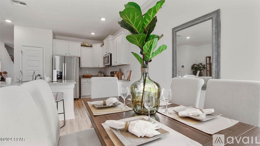 A modern dining room with a wooden table set for two.