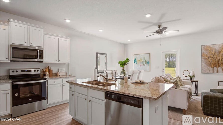 A kitchen with a large island and a fan on the ceiling.