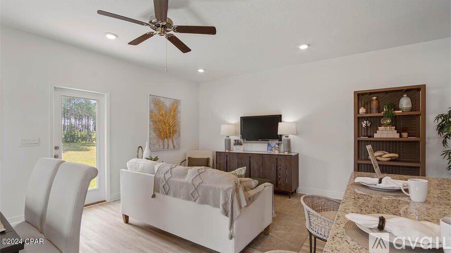 A living room with a white couch and a ceiling fan.